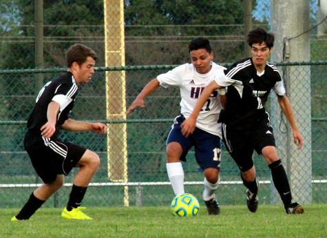 Junior Mario Murillo-Velasquez attempts to defend against two TA players.