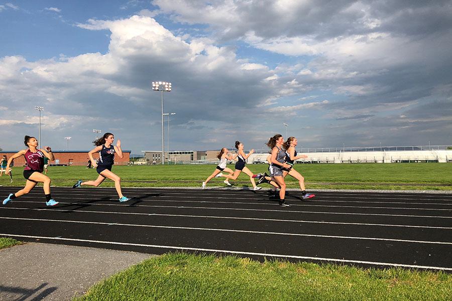 Seniors Carissa Roberts and Sydney Harper and freshman Elena Luhn run the 100 meter dash. Roberts reflects on what made her last season great.